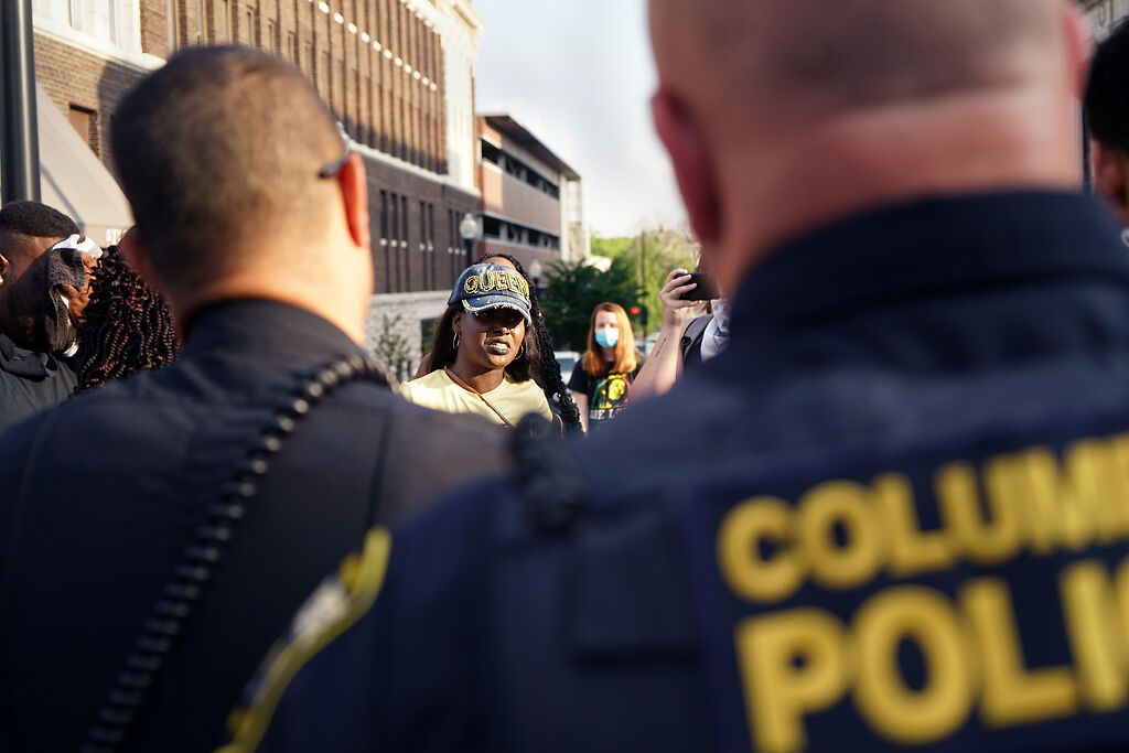 Protesters communicate with police officers Wednesday at the Broadway and Eighth Street intersection